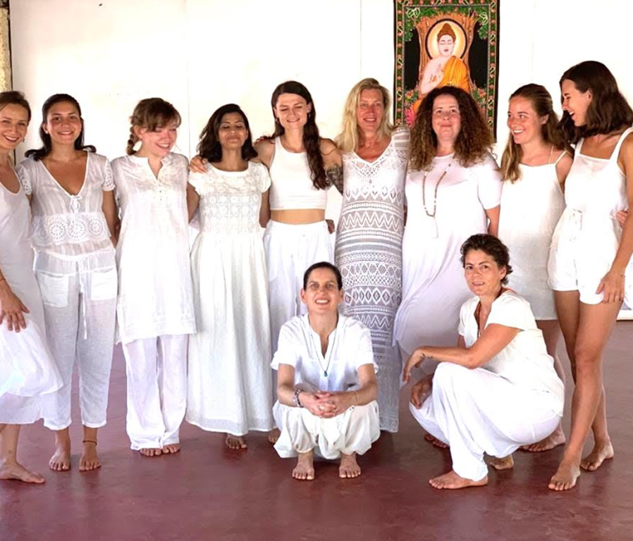 Participants in a 200-hour yoga teacher training in Goa practicing yoga poses outdoors at Diksha Yoga Hippie Paws Wellness Resort, surrounded by lush greenery.